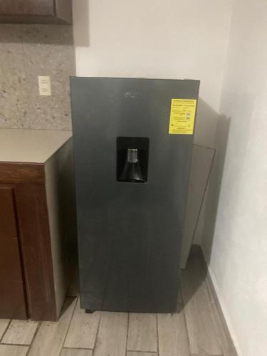 a black refrigerator with a yellow sticker on it at Departamento Familiar in Tampico