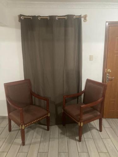 two chairs sitting in front of a curtain at Departamento Familiar in Tampico