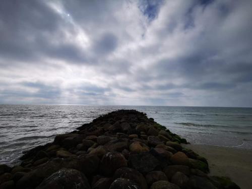 a pile of rocks on the shore of the ocean at Secluded Retreat in Blavand - By Traum Ferienwohnungen in Blåvand