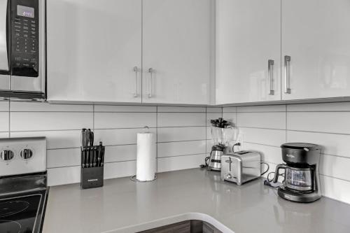 a kitchen with white cabinets and a counter top at Tropicana Stadium 2 Bed In DWTWN With Free Parking in St. Petersburg