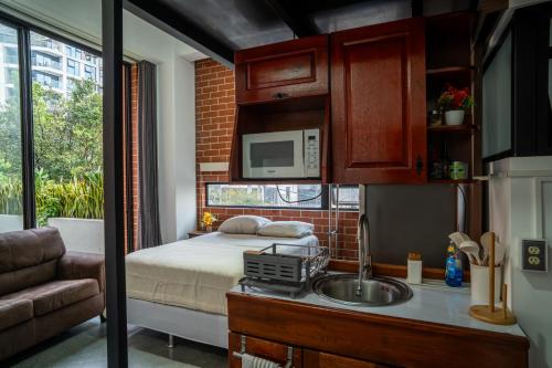 a kitchen with a bed and a sink in a room at Cómodo loft en centro de zona 4 in Guatemala