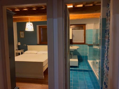 a bedroom with a bed and a bathroom with a tub at Da Luisa al Castello in Montemaggiore al Metauro