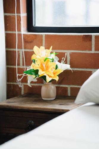 a vase filled with yellow and white flowers on a table at Cómodo loft en centro de zona 4 in Guatemala