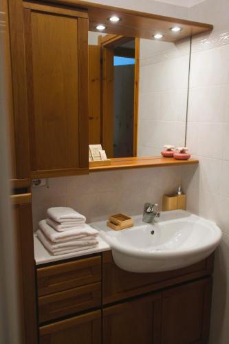a bathroom with a sink and a mirror and towels at Chalet Nausicaa in Lanzo dʼIntelvi
