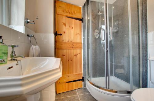 a bathroom with a shower and a sink at Mundles Cottage in Whittingham