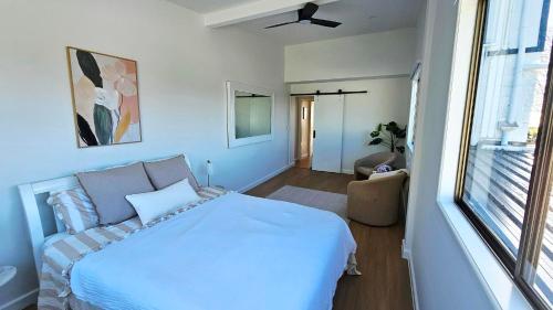 a bedroom with a large white bed and a window at Cielo Flaxton, Newly Renovated Luxury Accommodation with Ocean and Iconic Views in Flaxton