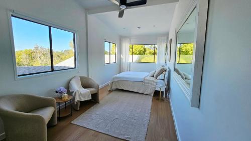 a bedroom with a bed and a mirror at Cielo Flaxton, Newly Renovated Luxury Accommodation with Ocean and Iconic Views in Flaxton