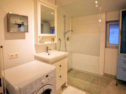 een badkamer met een wasmachine en een wastafel bij Rosenberger I und II in Hopfgarten im Brixental