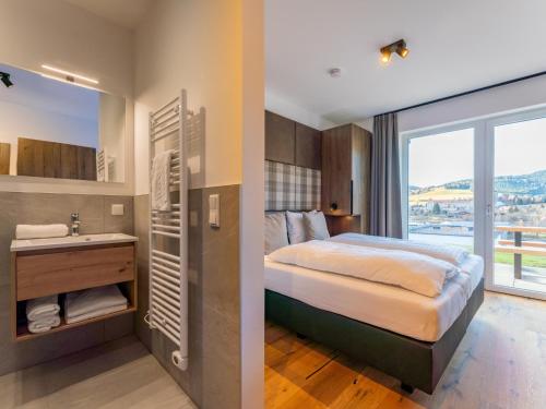 a bedroom with a bed and a sink and a window at Grebenzen Lodge 1028 in Sankt Lambrecht