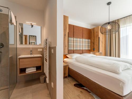 a bedroom with a large bed and a bathroom at Grebenzen Lodge 51 in Sankt Lambrecht