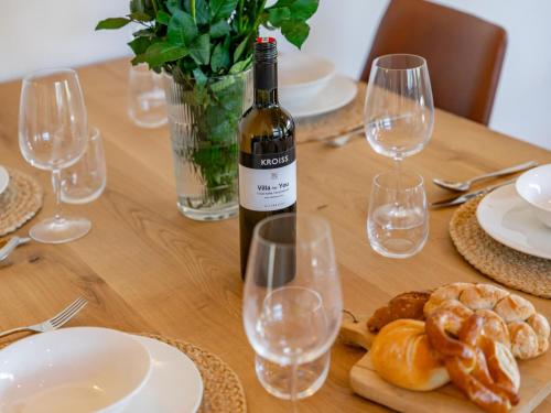 a bottle of wine sitting on a wooden table with glasses at Grebenzen Lodge 51 in Sankt Lambrecht