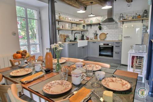 a kitchen with a table with plates of food on it at La maison de victorine in Dinan