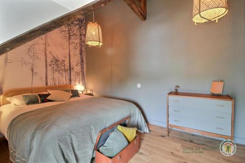 a bedroom with a bed and a dresser at La maison de victorine in Dinan