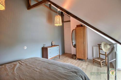 a bedroom with a bed and a staircase and a mirror at La maison de victorine in Dinan