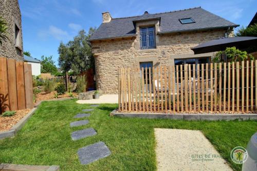 a fence in front of a stone house at La maison de victorine in Dinan