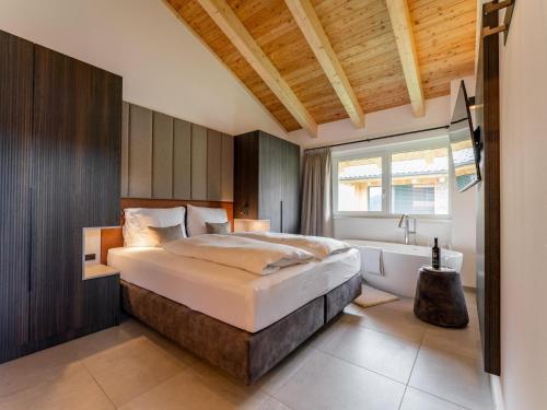 a bedroom with a large bed and a bath tub at Grebenzen Lodge 55 in Sankt Lambrecht