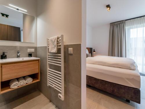 a bedroom with a bed and a sink and a mirror at Grebenzen Lodge 55 in Sankt Lambrecht