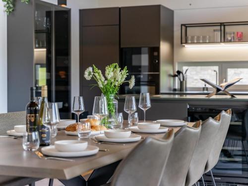 a dining room table with chairs and a table with wine glasses at Grebenzen Lodge 55 in Sankt Lambrecht