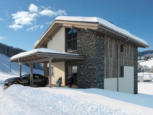 a snow covered building with a car parked in front at Grebenzen Lodge 55 in Sankt Lambrecht