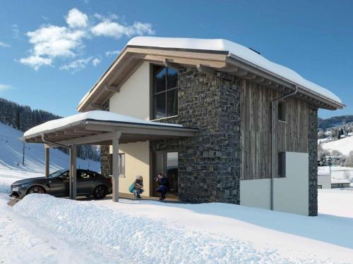 a snow covered building with a car parked in front at Grebenzen Lodge Edelblick in Sankt Lambrecht