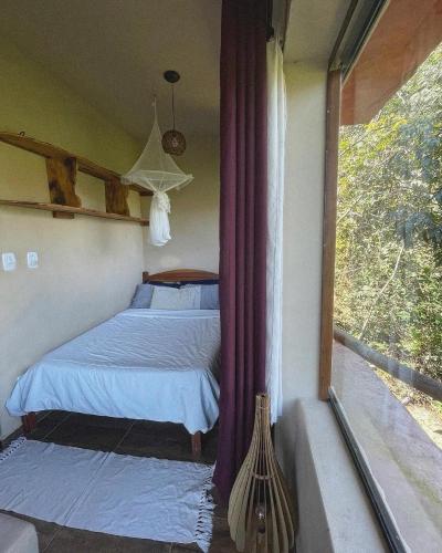 a bedroom with a bed and a window at Loft Urucum in Palmeiras