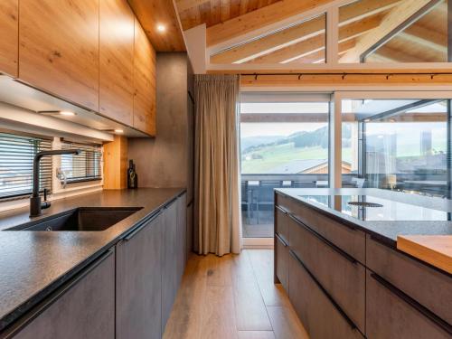 a kitchen with a sink and a large window at Grebenzen Lodge Edelblick in Sankt Lambrecht