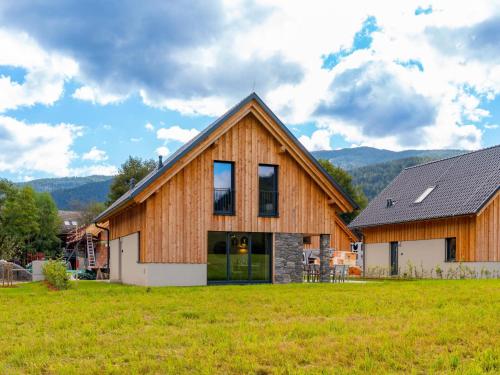 a large wooden house with a green field in front of it at Mountain Chalet An der Mur in Sankt Lorenzen ob Murau