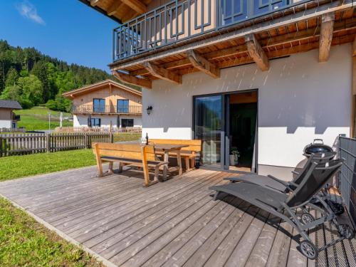 a wooden deck with a bench and a table at Obermöschach 7A in Obermöschach
