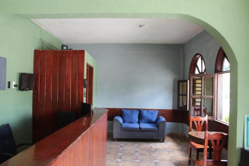 a living room with a blue couch and a chair at Hotel Colonial in Escárcega