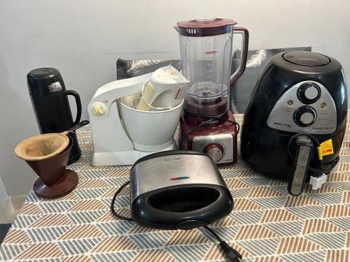 a counter with a blender and other appliances on it at APTO BEIRA MAR - ACONCHEGANTE _ VARANDA GOURMET - WIFI - NETFLIX - TV A CABO - PRAIA GRANDE in Praia Grande