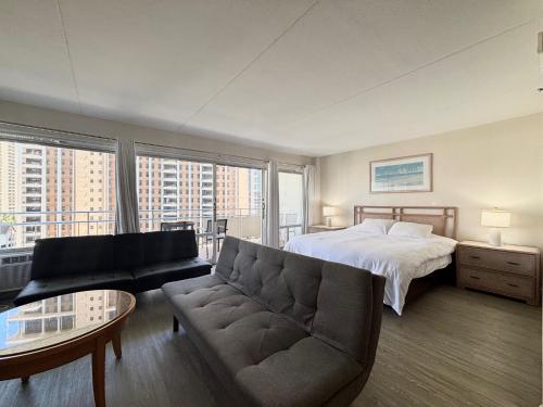 ホノルルにあるIlikai Apt 1042 - Spacious Studio with Ocean-Lagoon Viewsのベッドとソファのあるリビングルーム