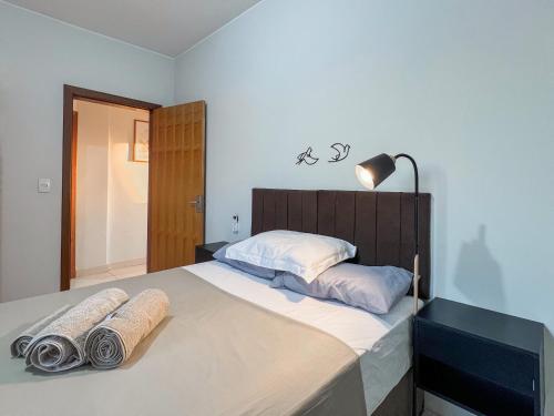 a bedroom with a large bed with towels on it at 303-AP Próx Unipam e Parq expo-AR-Elevador-Garagem in Patos de Minas