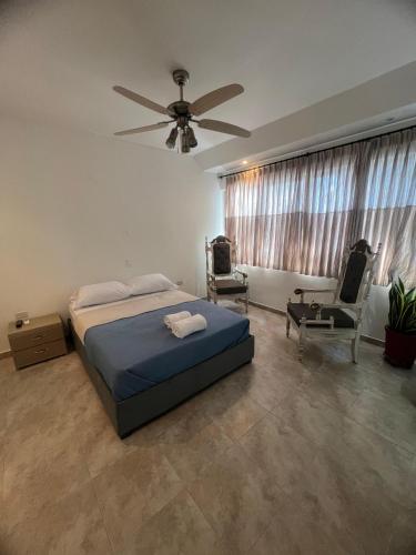 a bedroom with a bed and a ceiling fan at Casa Crespo Caribe Cartagena in Cartagena de Indias