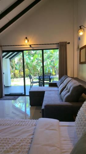 a living room with two beds and a couch at Nildiya Cottages in Elpitiya