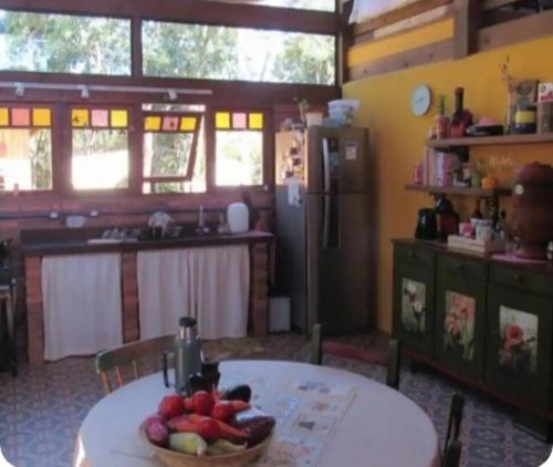 a kitchen with a table with a bowl of fruit on it at Casa Bosque Encantador in Rancho Queimado