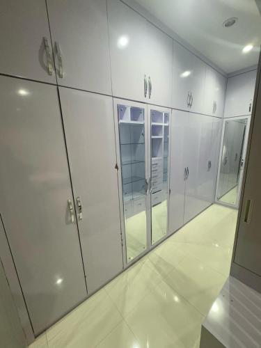 a row of white cabinets in a locker room at Elbara Guest House Syariah in Banjarbaru
