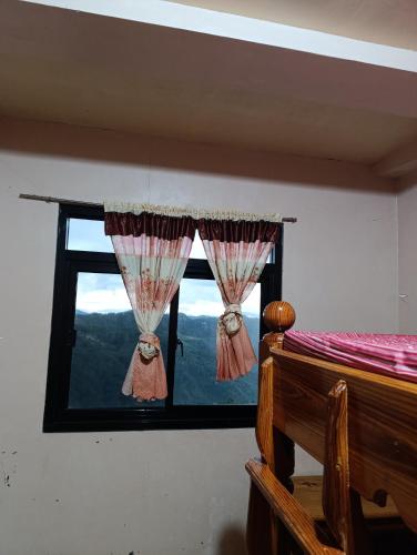 a bedroom with a window with a view of the mountains at Sea of clouds view inn in Sagada