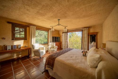 a bedroom with a large bed in a room with windows at Casa de Campo Los Sauces in Santa María