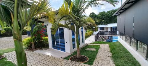 a house with palm trees in front of it at Hotel y Cabañas Parinzzi in Guatapé
