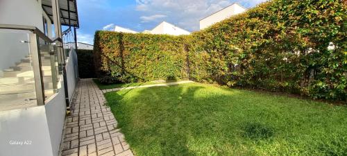 a backyard with a hedge and a grass yard at Hotel y Cabañas Parinzzi in Guatapé