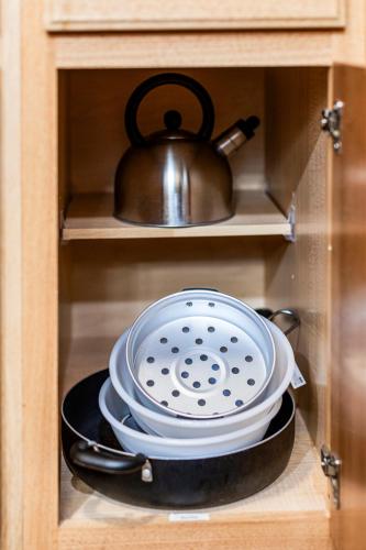 a stack of dishes in a cabinet with a tea pot at Amazing Superior Lake View Condo and Heated Pools in Two Harbors