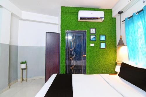 a bedroom with a bed and a green wall at OYO 82026 BANGUR INN in Nager Bazaar