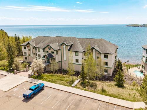 a house with a blue truck parked in a parking lot at Amazing Superior Lake View Condo and Heated Pools in Two Harbors