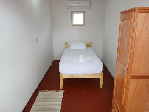 a small bed in a small room with a window at Casa mosaico in Asuncion