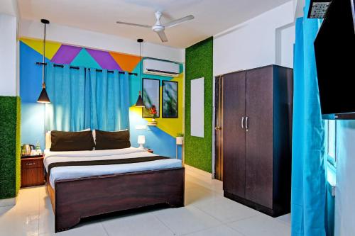 a bedroom with a bed with a colorful accent wall at OYO 82026 BANGUR INN in Nager Bazaar