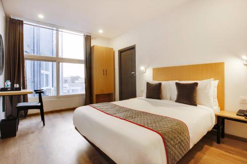 a hotel room with a large bed and a desk at Super townhouse moosapet Rcc Prime in Hyderabad