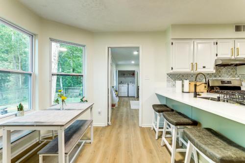 a kitchen with white cabinets and a table and stools at 5 Mi to Stone Mountain Family Home in Lithonia