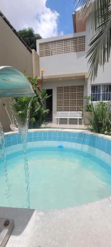 a swimming pool with a fountain in front of a building at Casa Loft 9C in São Luís