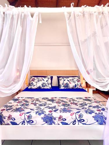 a bed in a room with white curtains at Villa Baobá Pousada & Spa in Búzios