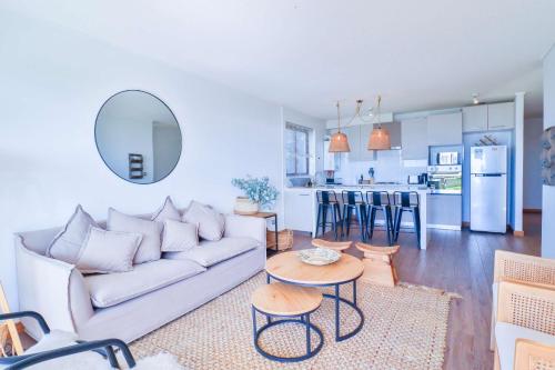 a living room and kitchen with a couch and a table at HOM I Depto familiar a pasos del lago in Puerto Varas
